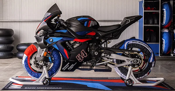 2026 BMW M 1000 RR superbike leaned through a racetrack corner in an outdoor performance scene.