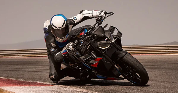 2026 BMW M 1000 R performance motorcycle on a racetrack in an outdoor landscape.